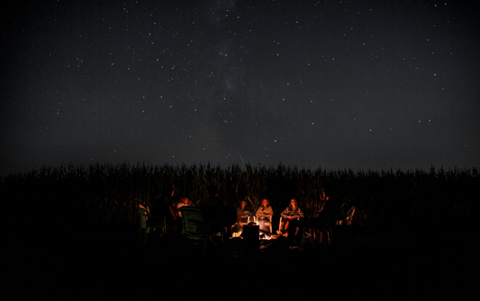 Starry night sky with campfire at a tent campsite