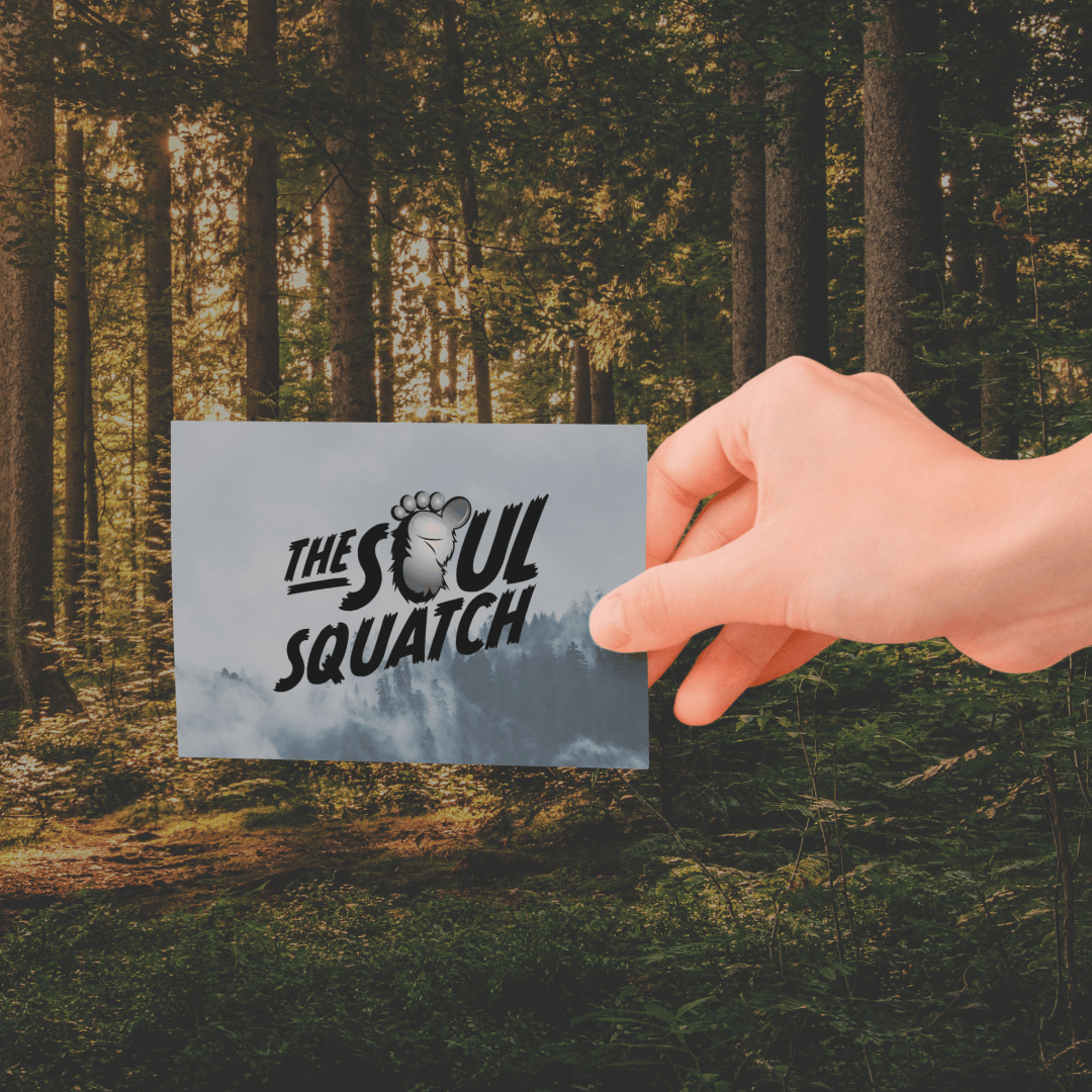 Hand holding a Soul Squatch gift card with misty forest background, symbolizing mystery and adventure.