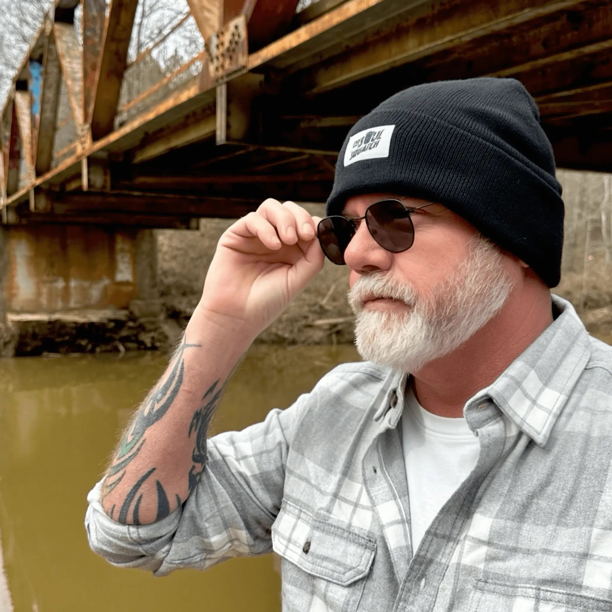 Man wearing the Nightfall Black, Sasquatch Soul Beanie — cuffed black knit beanie with patch logo, built for cold-weather trail wear.