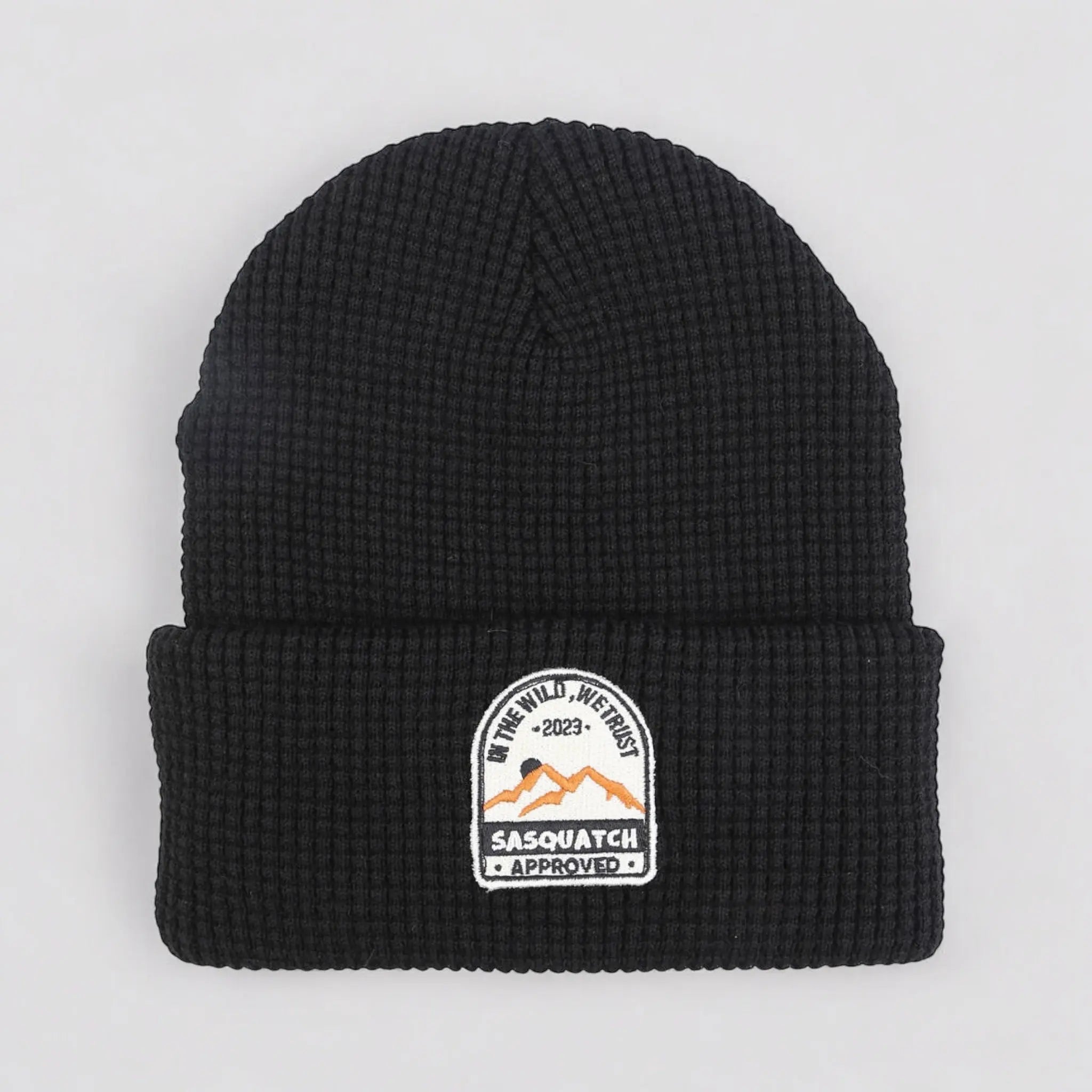 Flat lay of the Sunrise Summit Beanie in Shadow Mountain Black — black waffle-knit beanie with a sunrise mountain patch.