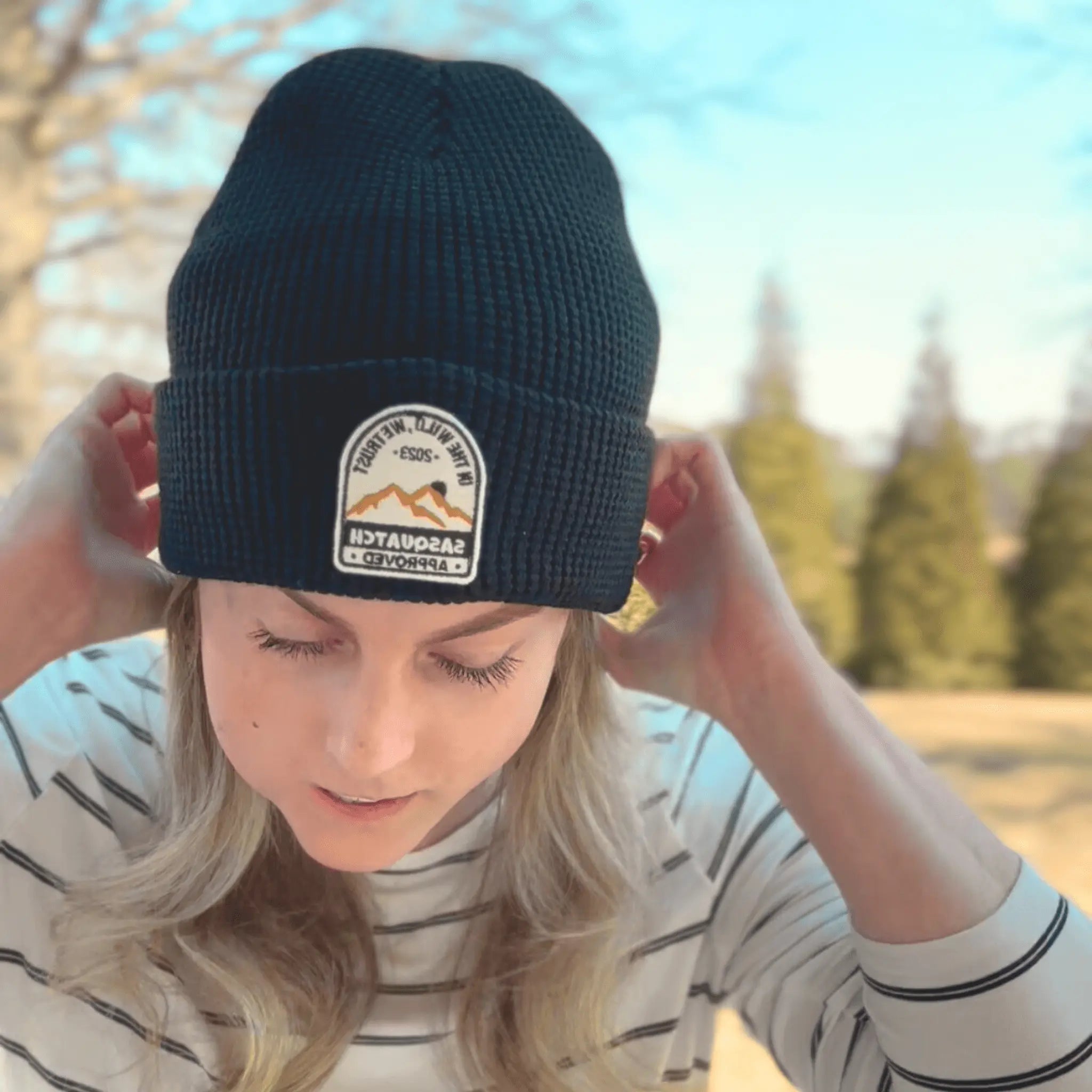 Woman wearing the Shadow Mountain Black, Sunrise Summit Beanie — waffle-knit black beanie with adventure patch, designed for cool-weather hikes.