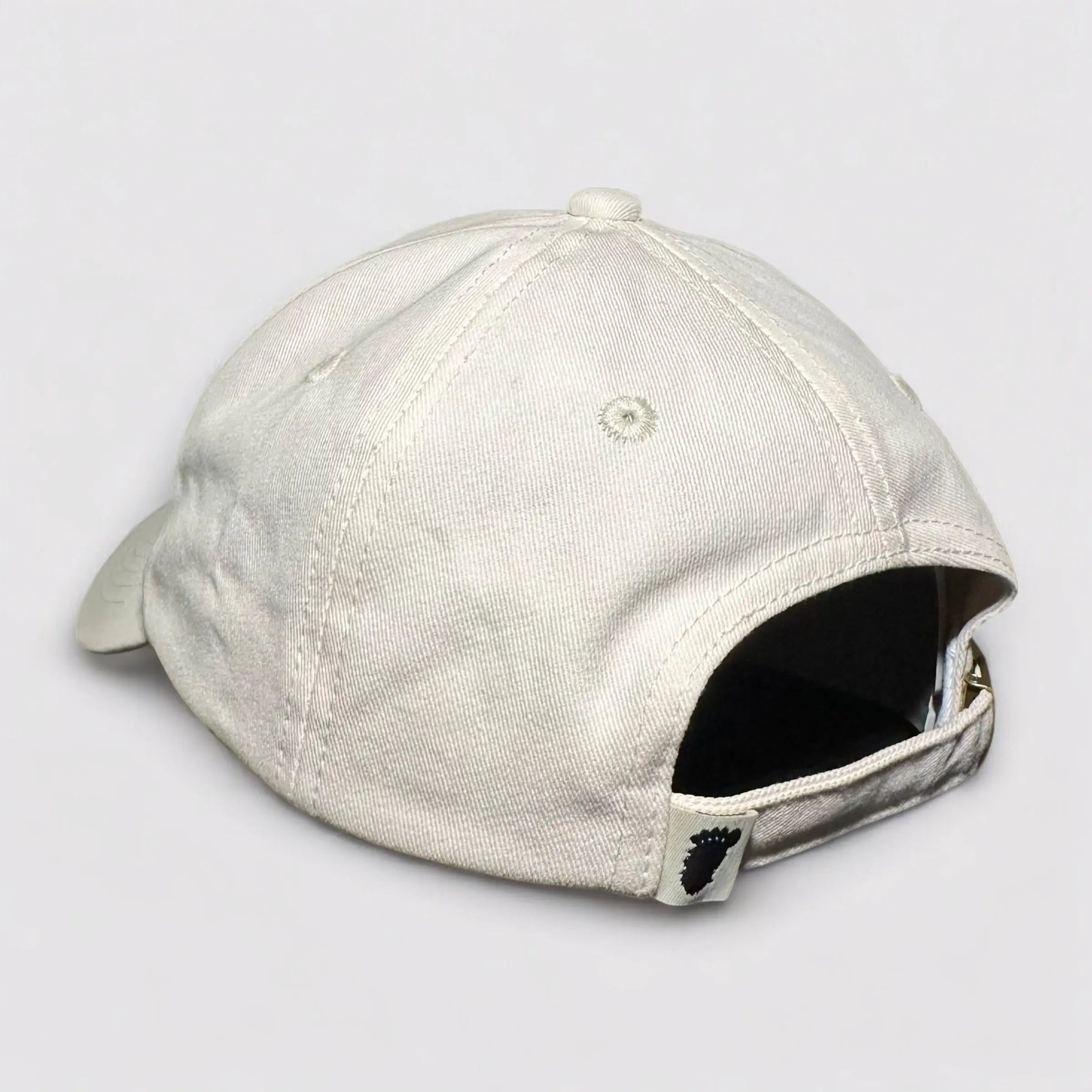 Angled flat lay of the Sandstone Trail Dad Hat displaying its back closure with a Soul Squatch woven tag and clean, rugged construction. Designed for eco-friendly explorers seeking comfort and durability.