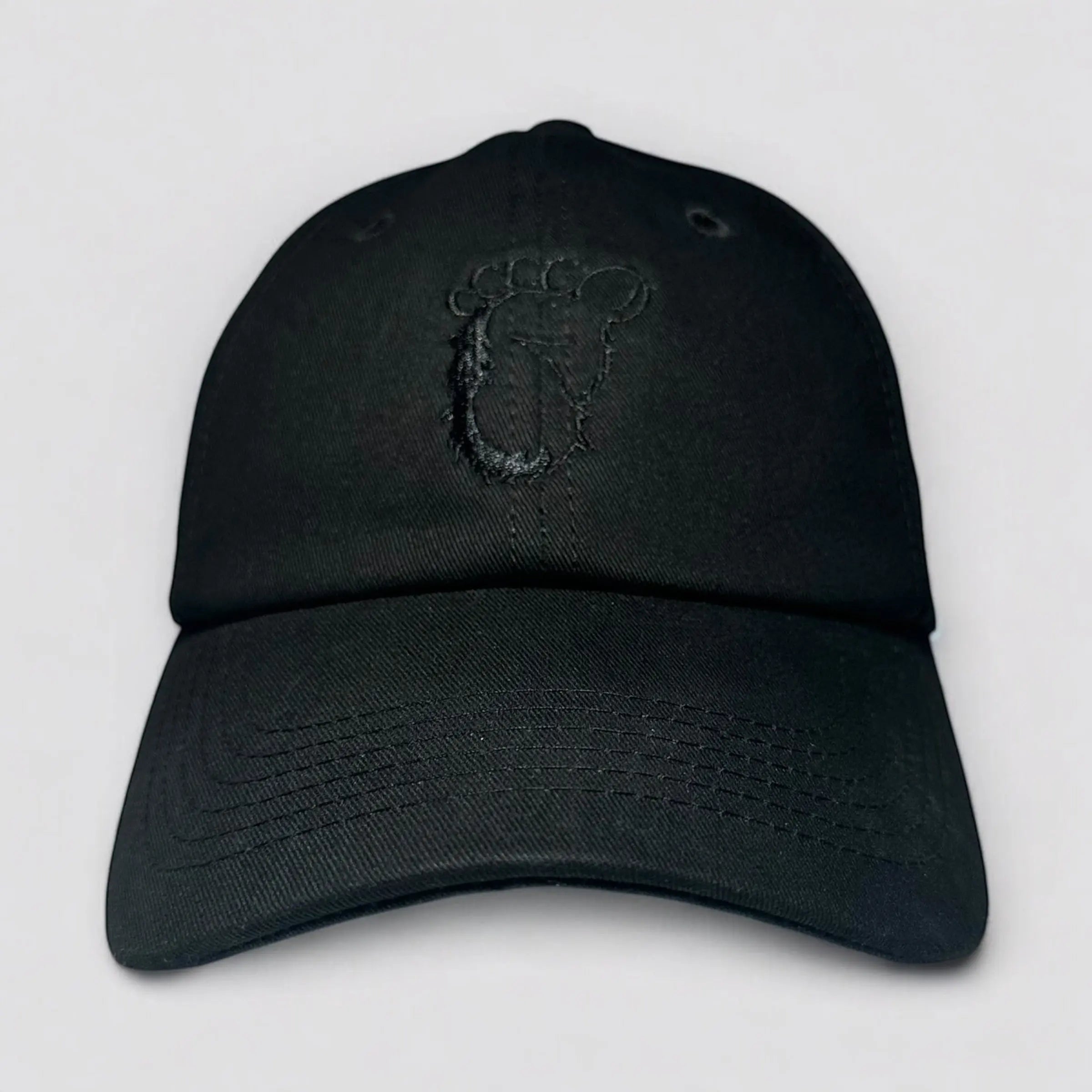 Flat lay of the Stealth Pine Dad Hat from The Soul Squatch in black, featuring a subtle embroidered Sasquatch footprint on the front panel. Made from recycled cotton, this low-profile dad hat is designed for eco-conscious adventurers and everyday explorers.