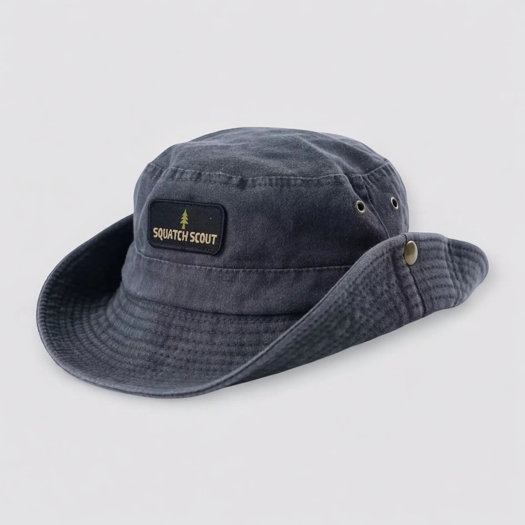 Angled flat lay of the Squatch Scout Boonie Hat showing durable stitching, side eyelets, and soft breathable cotton. Built for trail research, misty mornings, and sun-drenched treks.