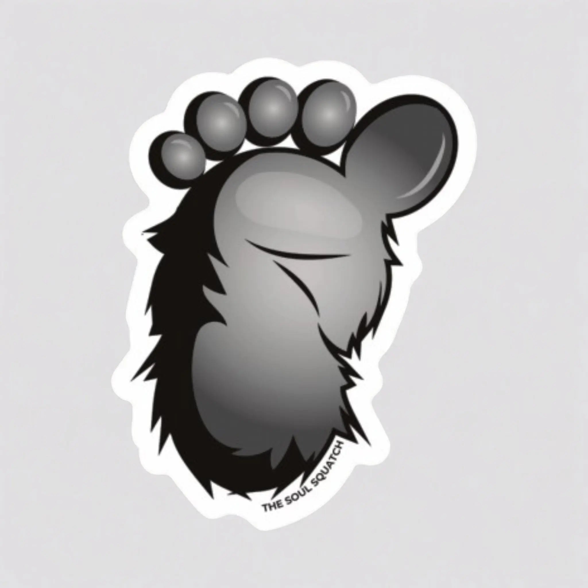 Flat lay of the Squatch Footprint Sticker — 2.32x3” waterproof vinyl sticker featuring a bold black-and-gray Bigfoot foot graphic with fur detail.