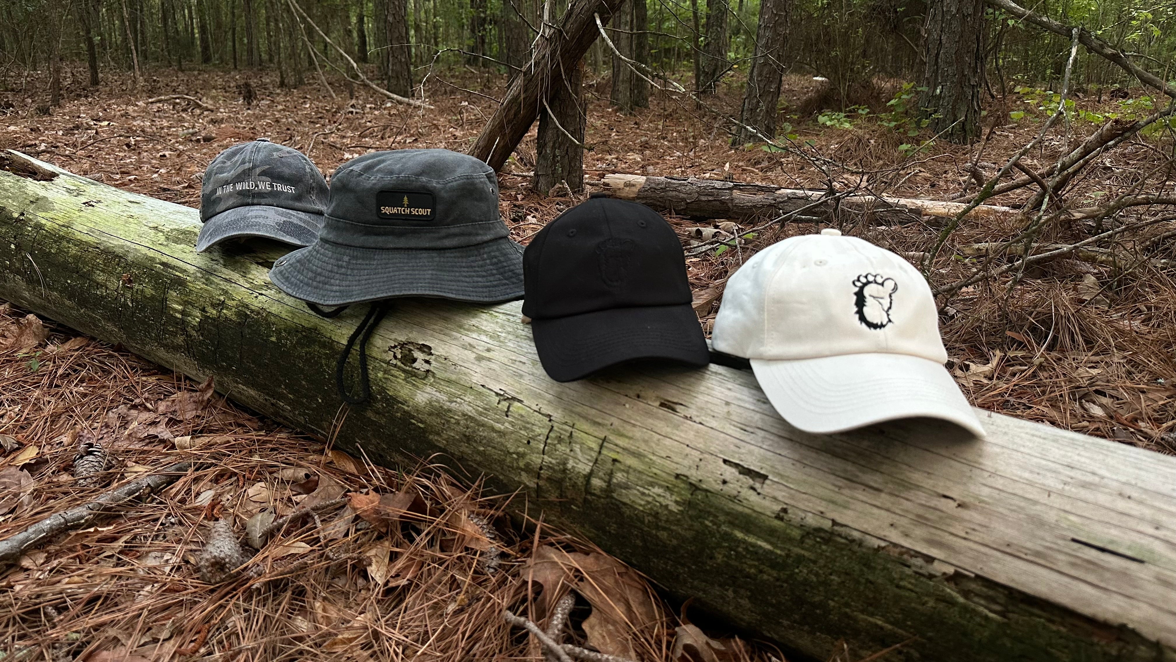 The Soul Squatch - 4 different hat styles sitting on a fallen tree log